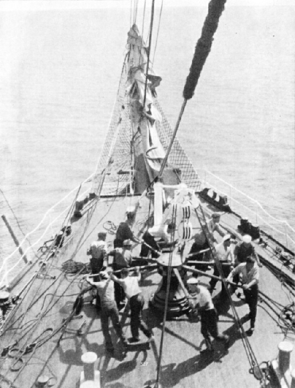 HEAVING THE CAPSTAN ROUND. The illustration shows the crew of the Penang raising the ship’s anchor by means of the capstan