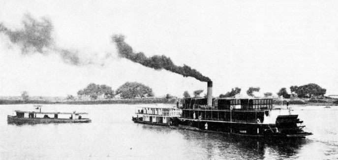 A PASSENGER BARGE being pushed ahead by a Sudan Government passenger stern-wheeler on the River Nile