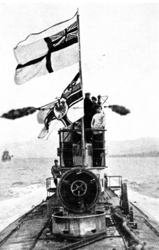 HANDED OVER TO THE BRITISH, this German submarine is flying the White Ensign above the German Ensign