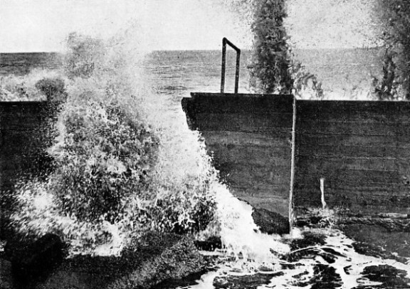 THE RELENTLESS SEA entering a breach in a newly-repaired sea wall at Lowestoft