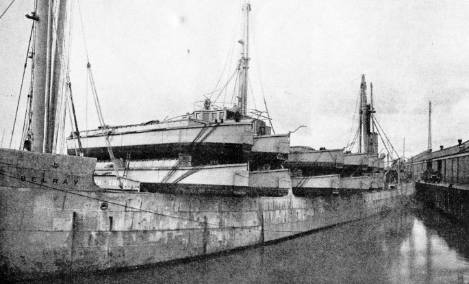 The Belray leaving Liverpool with twelve barges loaded across her forward deck